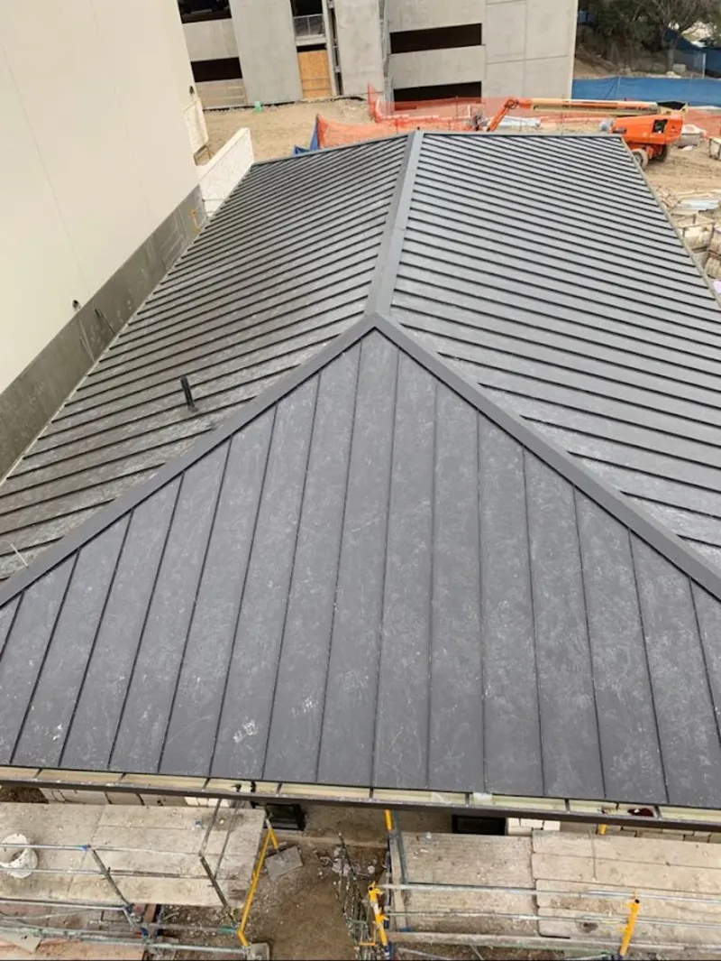 Commercial metal roof construction with crane equipment in Everman